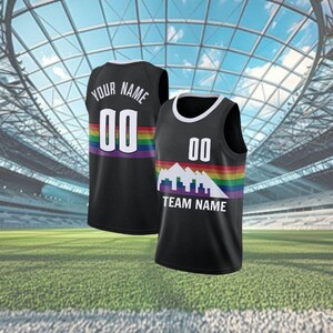 May include: Two black basketball vests with white trim. One vest has "YOUR NAME" and "00" on the back, above a rainbow stripe. The other vest has "00" and a mountain graphic with "TEAM NAME" below, also with a rainbow stripe.
