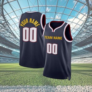 May include: Two navy blue basketball vests with white and red trim. One vest displays "YOUR NAME" and the number "00" in white and gold lettering. The other vest shows "TEAM NAME" and the number "00".