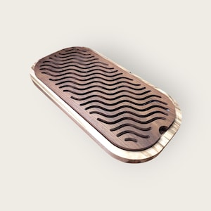 May include: A rectangular wooden tea tray with a dark brown, wave-patterned top and a light brown border. The tray has a recessed area for collecting spills and is designed for tea service.