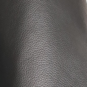 Pode incluir: Close-up de couro preto texturizado. O couro tem uma superfície granulada.