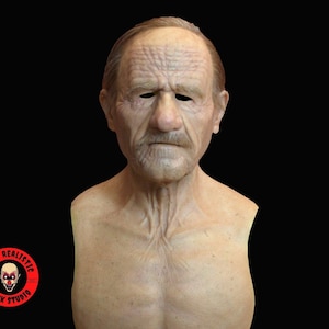 Puede incluir: Una máscara de silicona realista de un hombre mayor con arrugas y bigote. La máscara es de un tono de piel claro y tiene una escultura detallada.