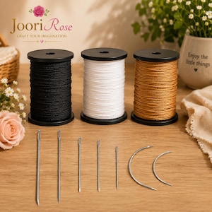 May include: Three spools of thread in black, white, and golden brown, each wound on a black plastic cylinder. Below the spools are seven metal sewing needles of varying lengths and shapes, including five straight needles and two curved needles.