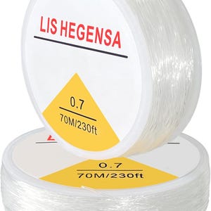 May include: Two clear spools of beading string are stacked. The top spool has the text "LIS HEGENSA" in red. The label reads "0.7" and "70M/230ft" in black on a yellow background. The string is tightly wound.