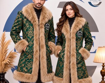 May include: Two long coats featuring a dark green fabric with a gold damask pattern, trimmed with thick tan faux fur along the collar, cuffs, and hem. Each coat displays a circular Shine Outlet logo on the chest and is worn over black.
