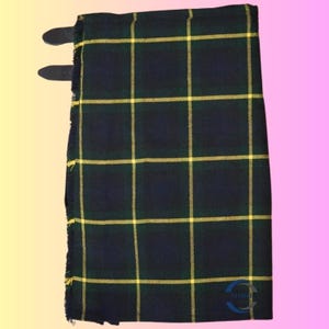 May include: A folded kilt in a dark blue, green, and yellow plaid pattern. The kilt has two leather straps with buckles. The fabric has a fringed edge. The kilt is a traditional Scottish garment.