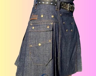 May include: A denim kilt with a black studded belt. The kilt features multiple pockets, brass-colored buttons, and a leather patch. The denim is a dark wash, and the kilt has a pleated design.