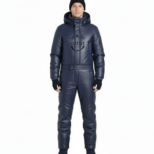 May include: A navy blue snowsuit with a matching hooded jacket and trousers. The jacket features the word "SHINE" and a logo. The person is wearing a black beanie and gloves. The snowsuit is made of a leather-like material.