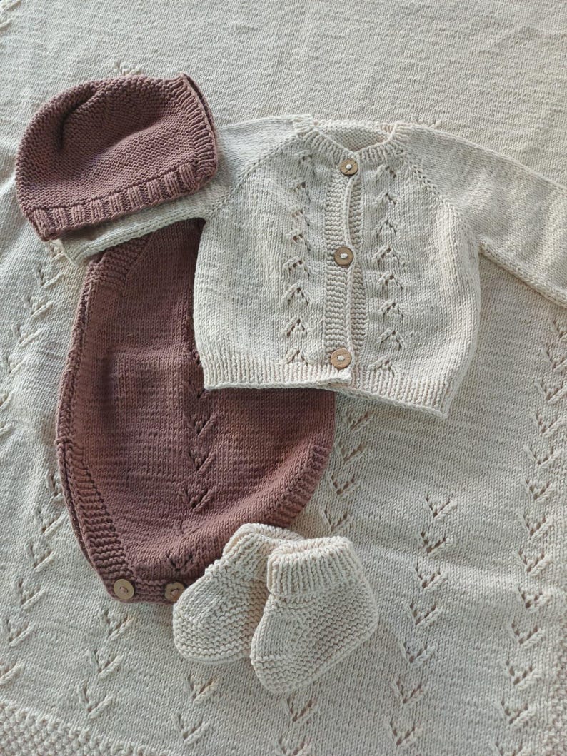 Handmade organic cotton knit baby outfit set including sweater, romper, booties, hat, and blanket. Made from 100% GOTS-certified organic cotton yarn, soft, breathable, and gentle on newborn skin. Available in multiple variations: hat and socks, hat socks cardigan, hat cardigan romper, or full 5-piece set. Custom color combinations available. Perfect for baby showers, coming-home outfits, or newborn photoshoots.