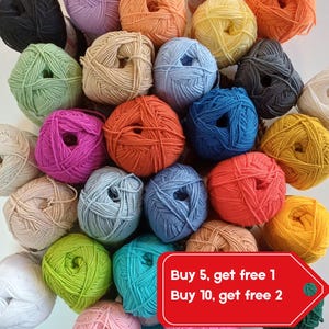 May include: A selection of colourful yarn balls in shades of pink, orange, blue, green, and yellow. The yarn is arranged to display the texture and vibrant hues. A red tag with white text is visible.