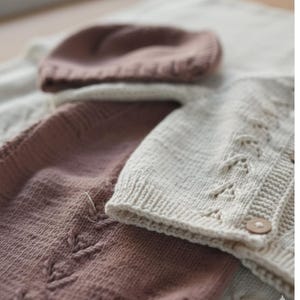 Handmade organic cotton knit baby outfit set including sweater, romper, booties, hat, and blanket. Made from 100% GOTS-certified organic cotton yarn, soft, breathable, and gentle on newborn skin. Available in multiple variations: hat and socks, hat socks cardigan, hat cardigan romper, or full 5-piece set. Custom color combinations available. Perfect for baby showers, coming-home outfits, or newborn photoshoots.