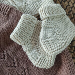 Handmade organic cotton knit baby outfit set including sweater, romper, booties, hat, and blanket. Made from 100% GOTS-certified organic cotton yarn, soft, breathable, and gentle on newborn skin. Available in multiple variations: hat and socks, hat socks cardigan, hat cardigan romper, or full 5-piece set. Custom color combinations available. Perfect for baby showers, coming-home outfits, or newborn photoshoots.