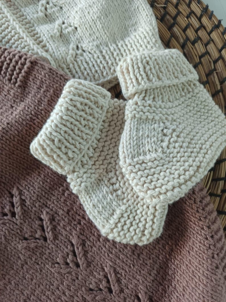 Handmade organic cotton knit baby outfit set including sweater, romper, booties, hat, and blanket. Made from 100% GOTS-certified organic cotton yarn, soft, breathable, and gentle on newborn skin. Available in multiple variations: hat and socks, hat socks cardigan, hat cardigan romper, or full 5-piece set. Custom color combinations available. Perfect for baby showers, coming-home outfits, or newborn photoshoots.
