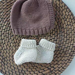 Handmade organic cotton knit baby outfit set including sweater, romper, booties, hat, and blanket. Made from 100% GOTS-certified organic cotton yarn, soft, breathable, and gentle on newborn skin. Available in multiple variations: hat and socks, hat socks cardigan, hat cardigan romper, or full 5-piece set. Custom color combinations available. Perfect for baby showers, coming-home outfits, or newborn photoshoots.