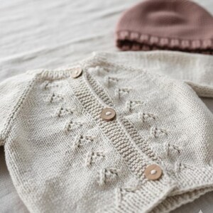 Handmade organic cotton knit baby outfit set including sweater, romper, booties, hat, and blanket. Made from 100% GOTS-certified organic cotton yarn, soft, breathable, and gentle on newborn skin. Available in multiple variations: hat and socks, hat socks cardigan, hat cardigan romper, or full 5-piece set. Custom color combinations available. Perfect for baby showers, coming-home outfits, or newborn photoshoots.