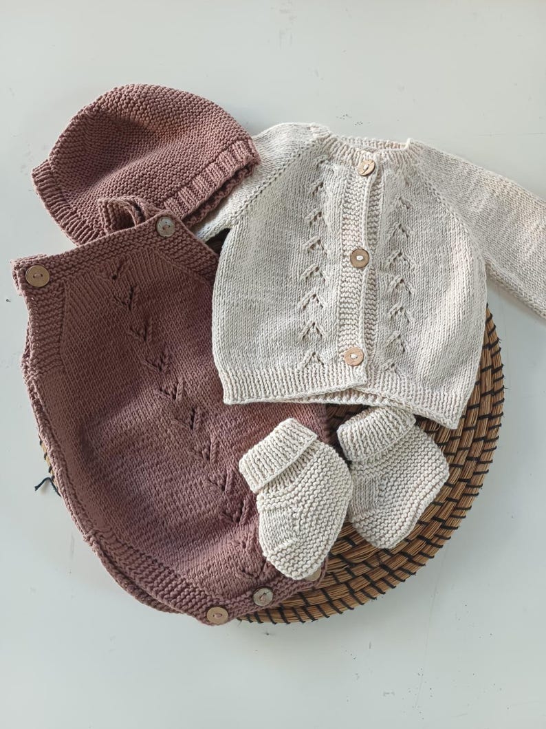 Handmade organic cotton knit baby outfit set including sweater, romper, booties, hat, and blanket. Made from 100% GOTS-certified organic cotton yarn, soft, breathable, and gentle on newborn skin. Available in multiple variations: hat and socks, hat socks cardigan, hat cardigan romper, or full 5-piece set. Custom color combinations available. Perfect for baby showers, coming-home outfits, or newborn photoshoots.