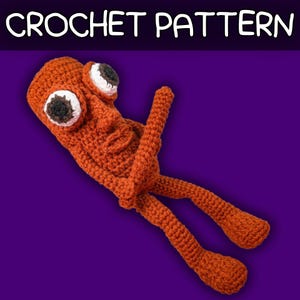 May include: A rust-coloured crochet doll with a textured surface, featuring two large protruding eyes with white sclera and dark brown pupils. The figure has a cylindrical head, a small nose, a simple mouth, two arms, and two long legs. Text reads CROCHET PATTERN.