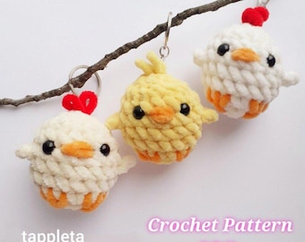 Peut inclure: Trois porte-clés en crochet en forme de poussin, un jaune, un blanc et un blanc avec une crête rouge. Les porte-clés sont suspendus à une branche. Le texte "Crochet Pattern PDF" est écrit sous les porte-clés.