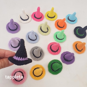Könnte beinhalten: Eine Sammlung bunter, gehäkelter Hexenhüte in verschiedenen Farben, darunter Rosa, Gelb, Grün und Lila. Jeder Hut hat einen kontrastierenden Rand und Kegel. Das Wort "tappleta" ist unten links sichtbar.