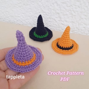 Può includere: Tre cappelli da strega all'uncinetto in miniatura viola, neri e arancioni. Il cappello viola ha una fascia arancione, il cappello nero ha una fascia verde e il cappello arancione ha una fascia nera. Il testo "Crochet Pattern PDF" è visibile.