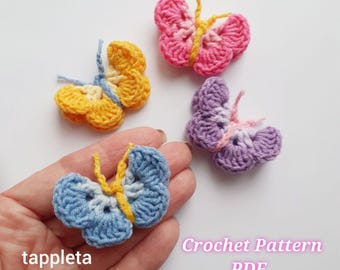 Puede incluir: Cuatro mariposas de ganchillo coloridas en tonos azules, amarillos, rosas y morados. Las mariposas tienen detalles amarillos y rosas. El texto "tappleta" y "Crochet Pattern PDF" son visibles en la imagen.