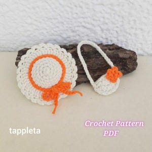 Op de afbeelding: Een gehaakte witte zonnehoed met een oranje rand en strik, naast een bijpassende witte handtas met een oranje bloem. De tekst "tappleta" staat links en "Crochet Pattern PDF" rechts.