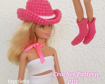 May include: A doll wearing a pink crocheted cowboy hat with a white band and matching pink crocheted boots. The doll is also wearing a white top and a pink ribbon. The text "Crochet Pattern PDF" is visible.