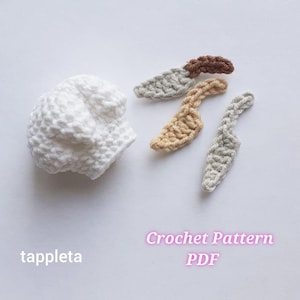 Könnte beinhalten: Ein weißer gehäkelter Hut und vier gehäkelte Messerapplikationen in Braun-, Beige- und Grautönen. Der Text "Crochet Pattern PDF" befindet sich in der unteren rechten Ecke, und das Wort "tappleta" befindet sich in der unteren linken Ecke.