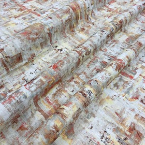 May include: Abstract fabric with a painterly design. The fabric features a blend of colors, including white, red, yellow, and brown, creating a textured, artistic appearance. The pattern resembles brushstrokes and overlapping rectangles.