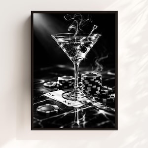May include: Black and white framed print featuring a martini glass with olives, smoke, and poker chips. The martini glass is in the center, with a stack of poker chips and playing cards visible.