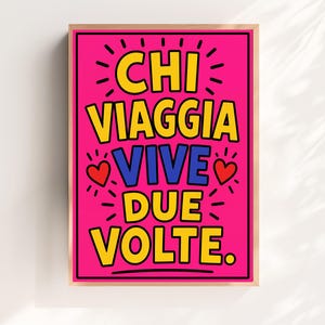 Peut inclure: Une affiche murale rectangulaire dans un cadre en bois clair avec un fond rose vif portant le texte CHI VIAGGIA VIVE DUE VOLTE en lettres jaunes et bleues, agrémenté de deux petits cœurs rouges et de détails en lignes noires rayonnantes.