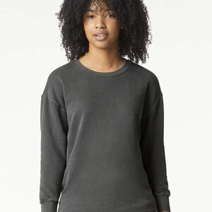 Pode incluir: Uma camisa de moletom cinza escuro com gola redonda e mangas compridas. A camisa de moletom &eacute; feita de um tecido macio e confort&aacute;vel e tem um caimento relaxado.
