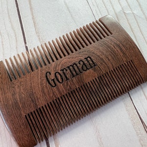 Peut inclure: Un peigne en bois brun avec une inscription personnalis&eacute;e qui dit "Gorman".
