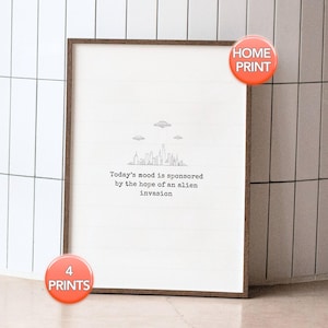 Könnte beinhalten: Ein gerahmter Druck mit weißem Hintergrund und braunem Rahmen. Der Druck zeigt eine minimalistische Strichzeichnung einer Skyline mit zwei fliegenden Untertassen darüber. Der Text lautet: "Today's mood is sponsored by the hope of an alien invasion."