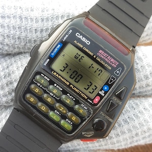 May include: A black Casio Wrist Remote Controller watch with calculator and alarm features. The digital display shows the time, date, and other data. The watch has a black strap and multiple buttons for various functions.