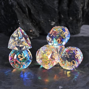 May include: A collection of iridescent, multi-faceted dice with gold numbering. The dice are in various geometric shapes, including a pyramid, a sphere, and a multi-sided die. The dice are set against a dark, textured background.