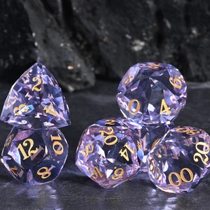Può includere: Un set di dadi sfaccettati viola con numeri dorati. I dadi sono disposti su una superficie scura e strutturata, con uno sfondo scuro. Questi dadi sono progettati per i giochi da tavolo.