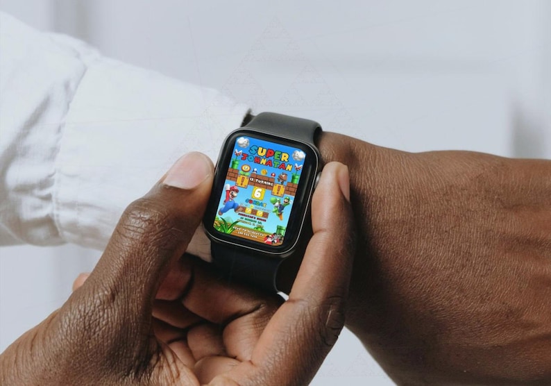 May include: A black smartwatch displaying a colorful video game scene with the text "SUPER JORNATAN". The game features a cartoon character in a red outfit. The watch is on a wrist.