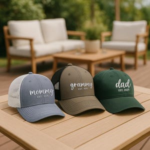 Pu&ograve; includere: Tre cappellini da baseball con le parole "mommy", "grammy" e "dad" ricamate. Il cappellino "mommy" &egrave; blu con il retro in rete bianca. Il cappellino "grammy" &egrave; verde oliva con il retro in rete nera. Il cappellino "dad" &egrave; verde scuro.
