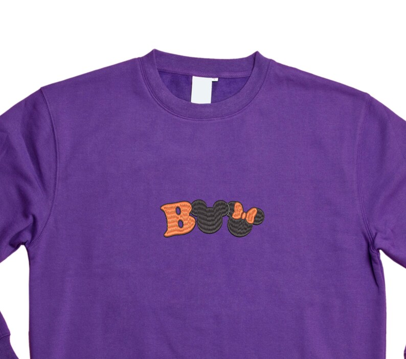 May include: Purple sweatshirt with a black and orange embroidered "Boo" design.