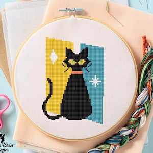 May include: A black cat with yellow eyes sits in front of a yellow and blue geometric background. The cat is wearing a red collar. The background has a white star on the blue side.