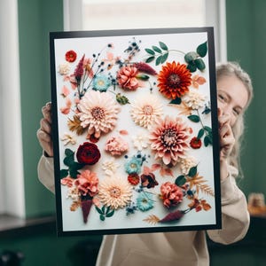 May include: A framed floral art print featuring a variety of colorful flowers in shades of red, pink, orange, and blue. The flowers are arranged on a white background, creating a vibrant and eye-catching display. The frame is black.