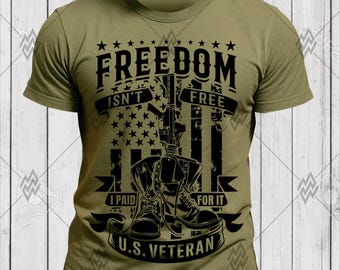 Puede incluir: Camiseta verde oliva con un diseño gráfico que incluye el texto "FREEDOM ISN'T FREE I PAID FOR IT U.S. VETERAN". El diseño presenta una bandera americana, botas militares y un rifle.