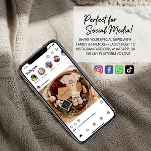 May include: A smartphone displays an Instagram feed with a baby-themed gift basket. The basket contains a onesie, booties, and a wooden sign that says "Christmas". The text on the screen says "Perfect for Social Media!" and social media icons are visible.