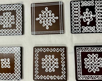 May include: Six brown square coasters with white geometric designs. Each coaster features a unique pattern, including dots, lines, and intricate shapes. The coasters are arranged in a grid, showcasing the variety of designs.