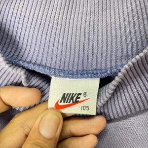 May include: A white ceramic mug with a black handle and the text "But First, Coffee" in a handwritten style. The mug is on a white surface. The mug is 4 inches tall.