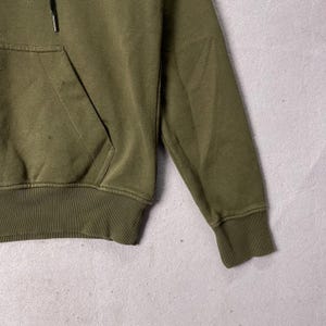 Puede incluir: Sudadera con capucha verde oliva con bolsillo de canguro y cord&oacute;n. Los pu&ntilde;os y el dobladillo acanalados son del mismo color que el resto de la prenda. La sudadera con capucha est&aacute; hecha de un material suave y c&oacute;modo.