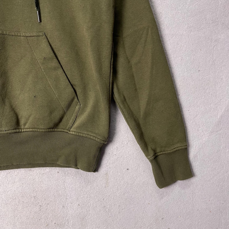 Puede incluir: Sudadera con capucha verde oliva con bolsillo de canguro y cord&oacute;n. Los pu&ntilde;os y el dobladillo acanalados son del mismo color que el resto de la prenda. La sudadera con capucha est&aacute; hecha de un material suave y c&oacute;modo.