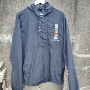May include: Navy blue hooded anorak jacket with a drawstring and snap closure. Features a small graphic of flags and the text "World Cup 94". Includes two front pockets and a drawstring at the hem.