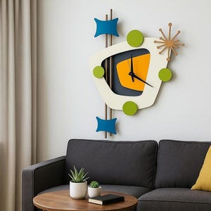 May include: A wall clock featuring an asymmetrical cream-coloured frame with a dark grey interior and a central orange shape. It includes three green circular accents, two blue geometric shapes, and a brown starburst element on vertical rods.
