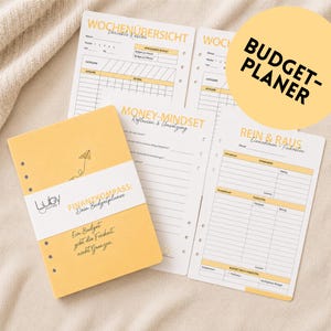Peut inclure: Un planificateur budgétaire jaune avec le texte "FINANZKOMPASS: Dein Budgetplaner" et "Ein Budget gibt dir Freiheit nicht Grenzen". Le planificateur comprend plusieurs pages avec des modèles de planification financière et les mots "WOCHENÜBERSICHT", "MONEY-MINDSET" et "REIN & RAUS".